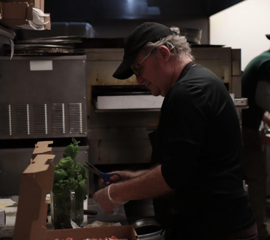 The owner of Bellerias, Tom, makes a pizza in the kitchen of his restaurant. 