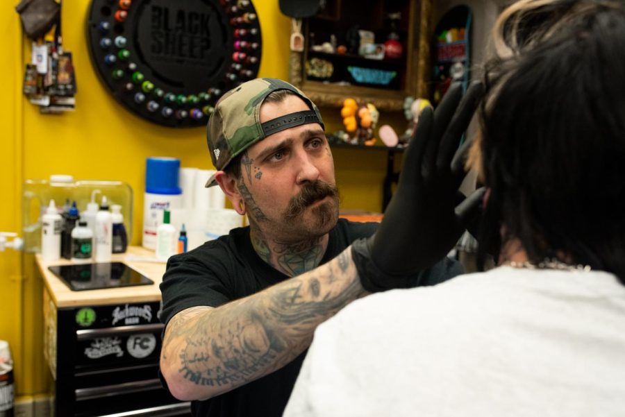 Black Sheep Tattoo Studios Owner Alex Barba prepares customer Cali Coreno for a face tattoo. The shop is located in downtown Ravenna. 