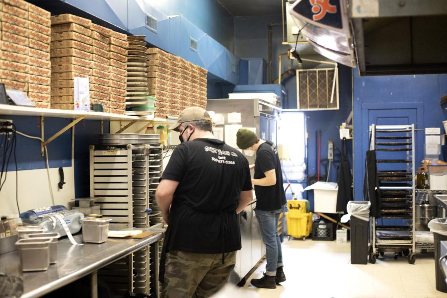 Manager Eric and a worker at Guyss Pizza Co. prepare pizza and other food.  Guys Pizza Co. is located at 146 South Water Street in Kent, Ohio.