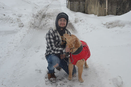 Trevor Steem poses with his dog Massimo on Thursday, Feb. 3, 2022. Steem is a sophomore zoology major and McDowell Hall resident at Kent State University. He and Massimo were out walking around campus Thursday morning during the Thursday campus closure.