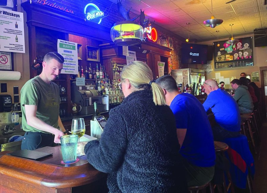 Bartender Chris Allen refills a drink for customers eating at the bar at Rays Place on March 20. Rays is located at 135 Franklin Ave.