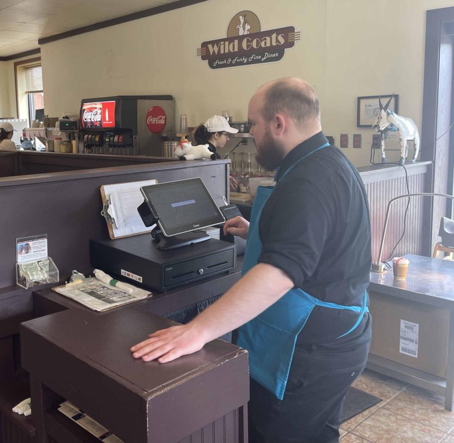 Zach, an employee at Wild Goats, grabs a check for a table on March 20. Wild Goats is located at 319 W. Main St.