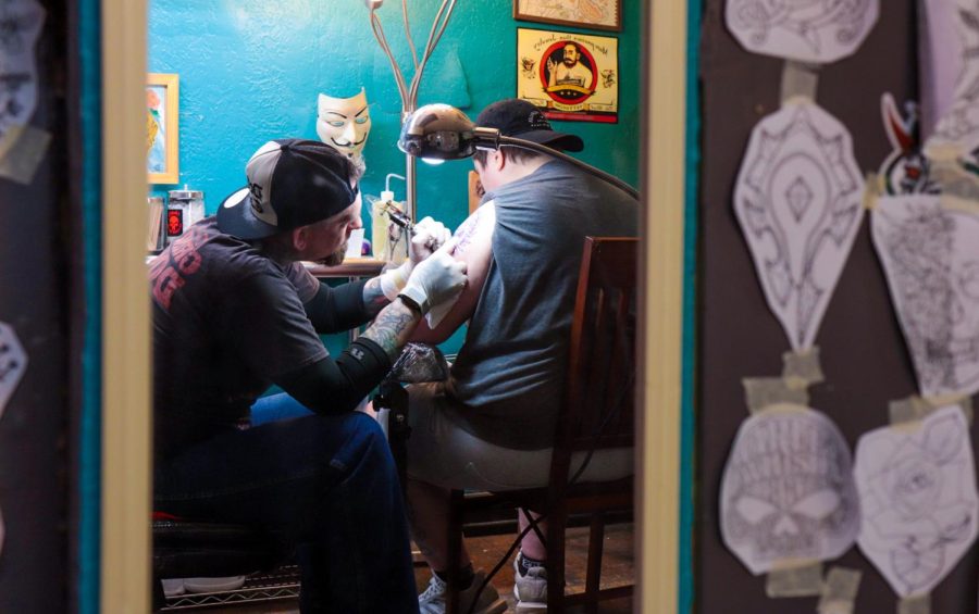 A tattoo artist starts a tattoo on a Kent students arm at Defiance in downtown Kent.