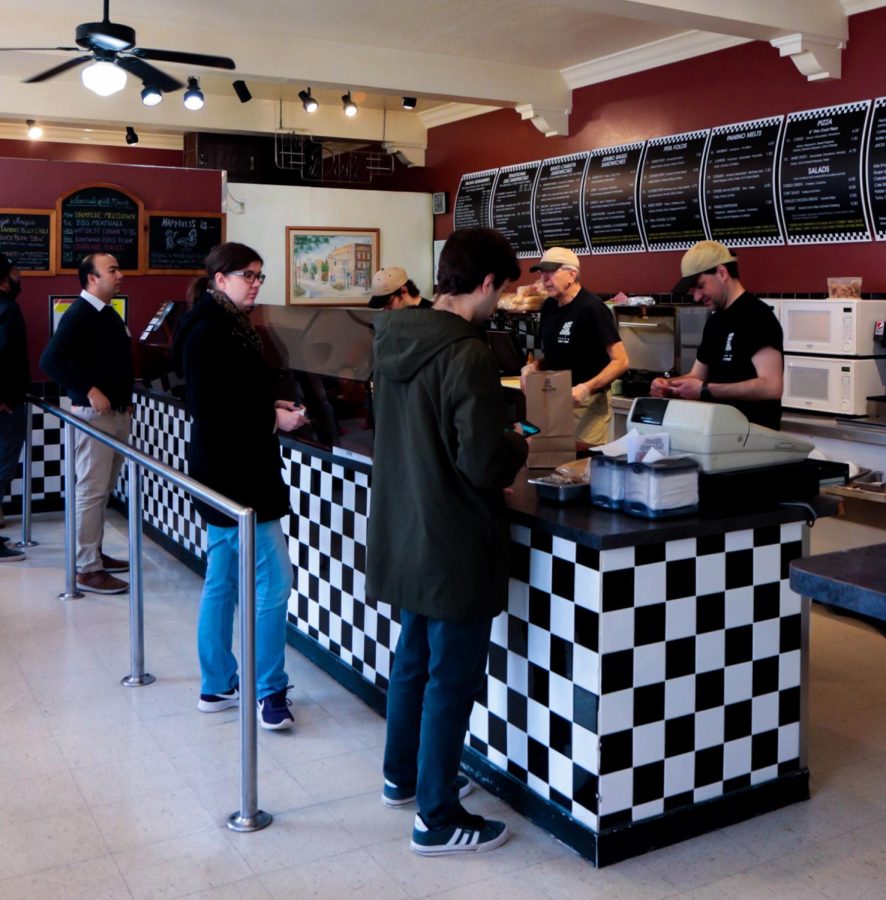 Customers wait in line for a sandwich during lunch time at Franklin Square Deli in downtown Kent.