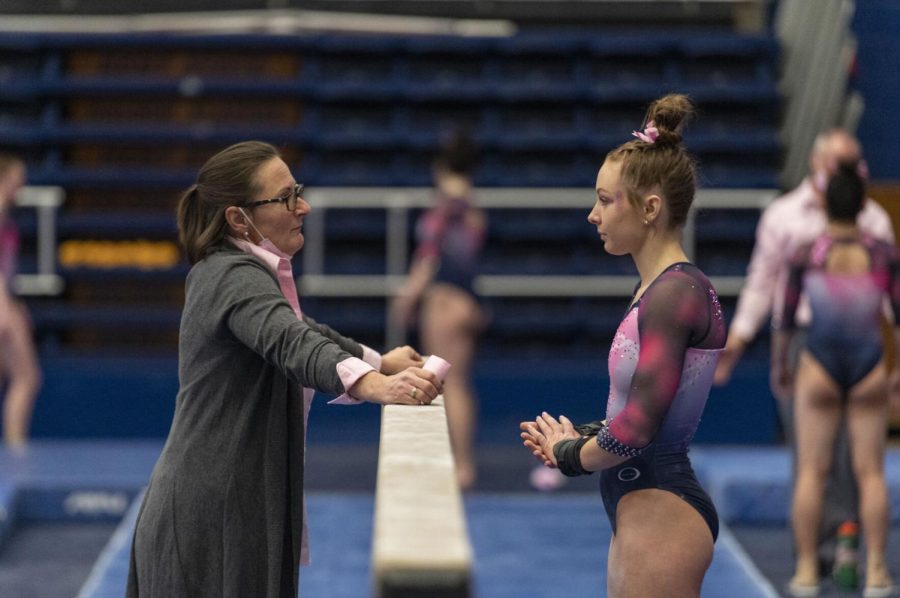 Assistant Coach Sharon Sabin gives Kent senior Rachel Decavitch a pep talk before she competes on balance beam during the gymnastics competition against Bowling Green at the M.A.C. Center on Feb. 20, 2022. The judges gave Decavitch a score of 9.825 for her performace on the balance beam.
