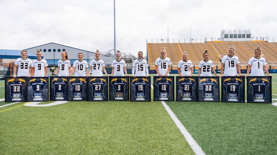 Senior+members+of+the+Kent+State+lacrosse+team+pose+with+their+framed+jerseys.+