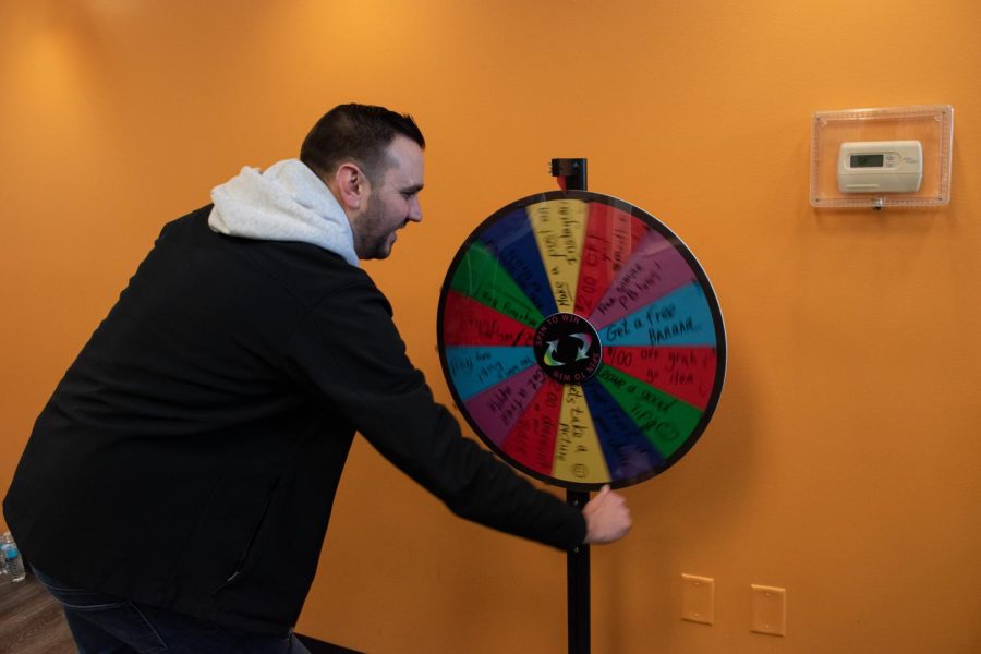 A man spins the wheel for a prize after getting a hole-in-one at Kwench Juice Cafe.