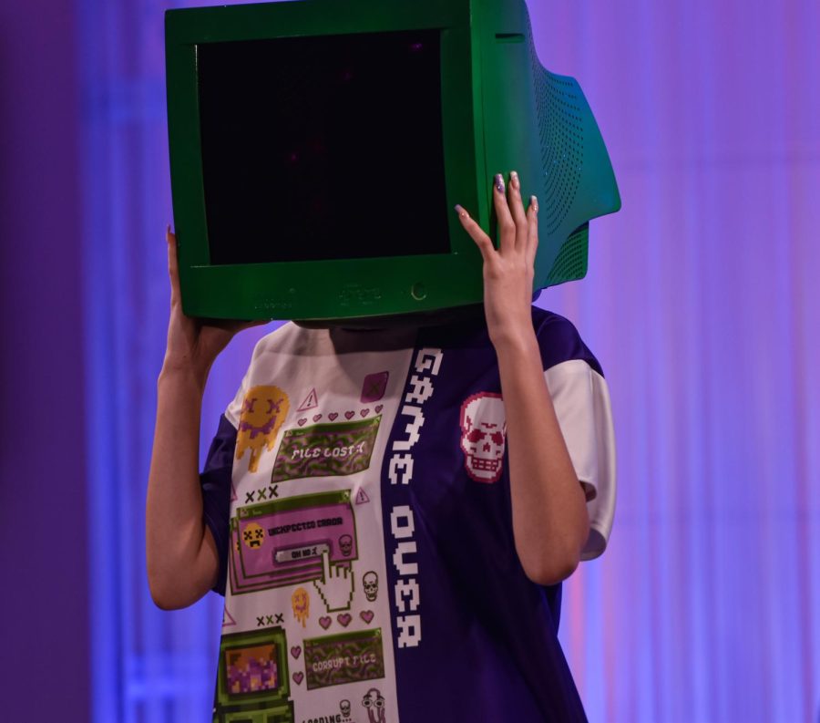 A Kent State student models a striking outfit featuring a TV head during the annual fashion show on April 28, 2022.