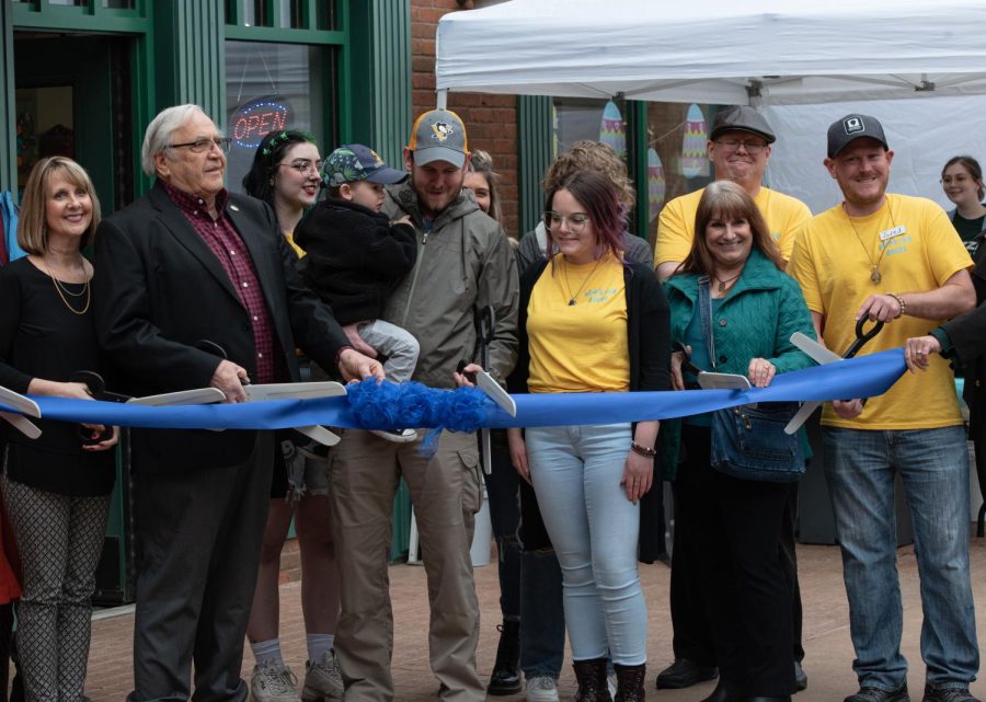 Hippie Fox Rocks owner Jared Abell (far right), Mayor Fiala (left) and others cut the ribbon during the stores grand opening on April 6, 2022.