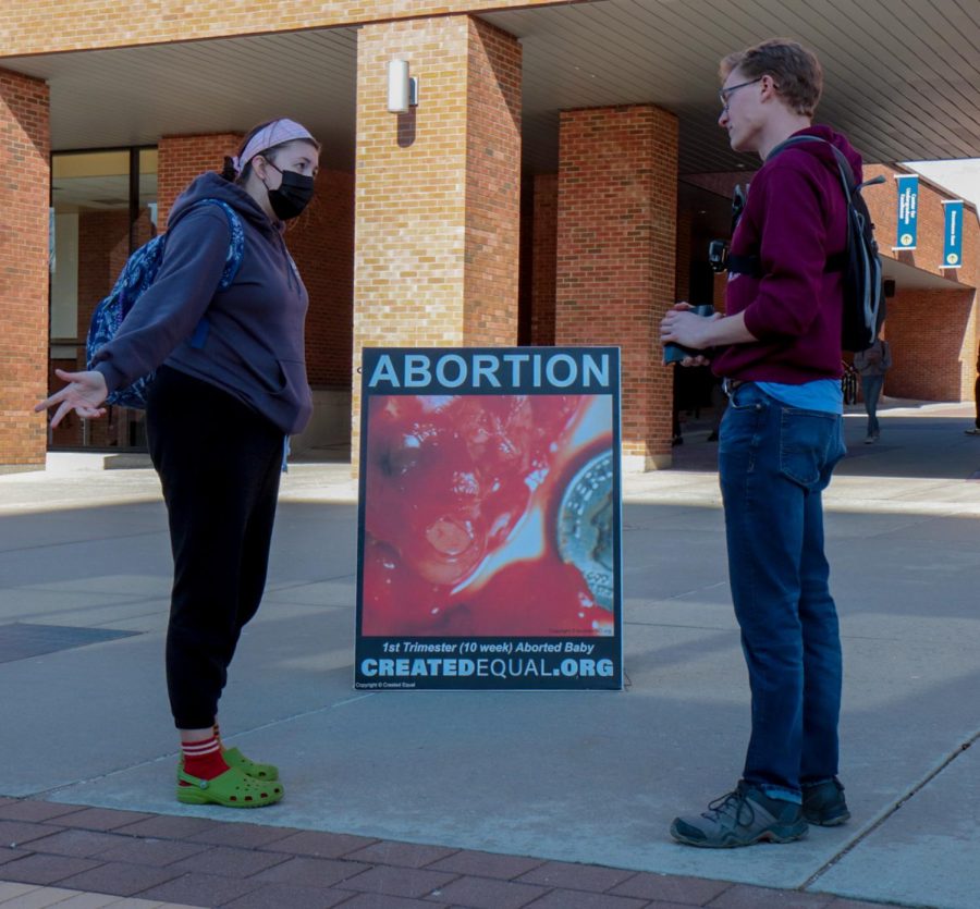 Isaac, pictured on the right, has a discussion with a Kent State student about his views on abortion at an anti-abortion demonstration on the K on Thursday, April 7. Isaac said he believes abortion is blatantly against what the Bible teaches.
