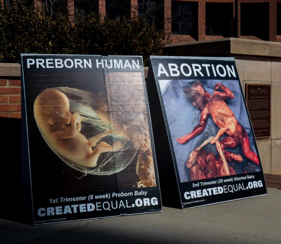 Two of the many signs the anti-abortion demonstration put on by the organization Created Equal on the K on Thursday, April 7. Evangeline, the director of the demonstration, said they are there to talk to people about abortion because its intentions are to kill.