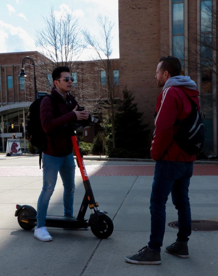 Seth, pictured on the right, has a conversation with Holden, a Kent State student expressing his views on abortion at an anti-abortion demonstration on the K on Thursday, April 7.