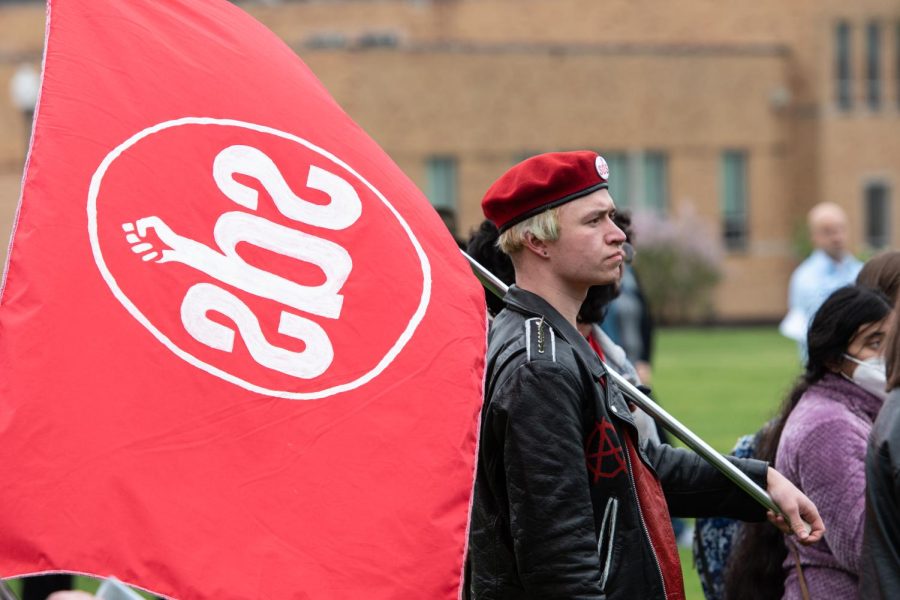 Kent State junior and Students for a Democratic Society member Haydn Palmer attends the May 4 Commemoration with the SDS flag in tow.