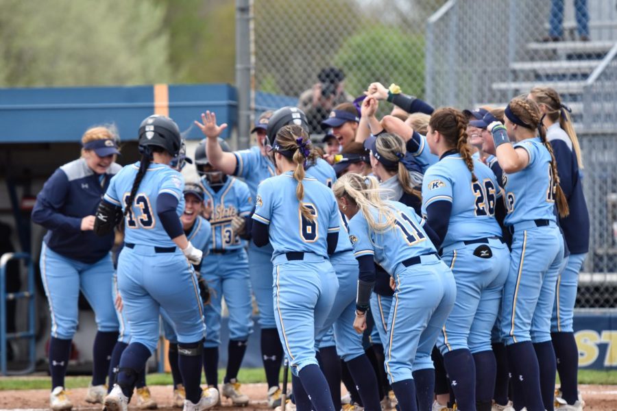 The Kent State softball team celebrates as 5th year Brenna Brownfield makes it to home base after making a two point home-run.