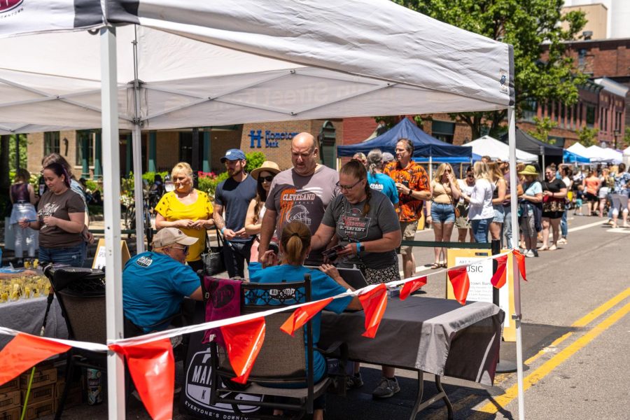 Main Street Kent employees working their booth during the Art and Wine Festival on June 4, 2022. Staff distributed tasting glasses, selling wristbands and drink tickets.