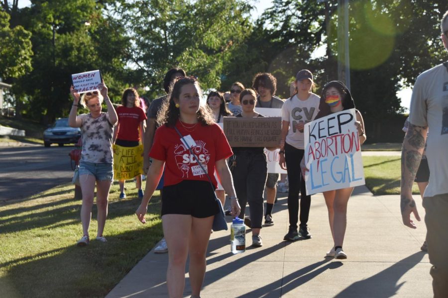 Fionna Fisher, SDS organizer and senior sociology major, leads the group as they march towards the Kent State rock on June 24.