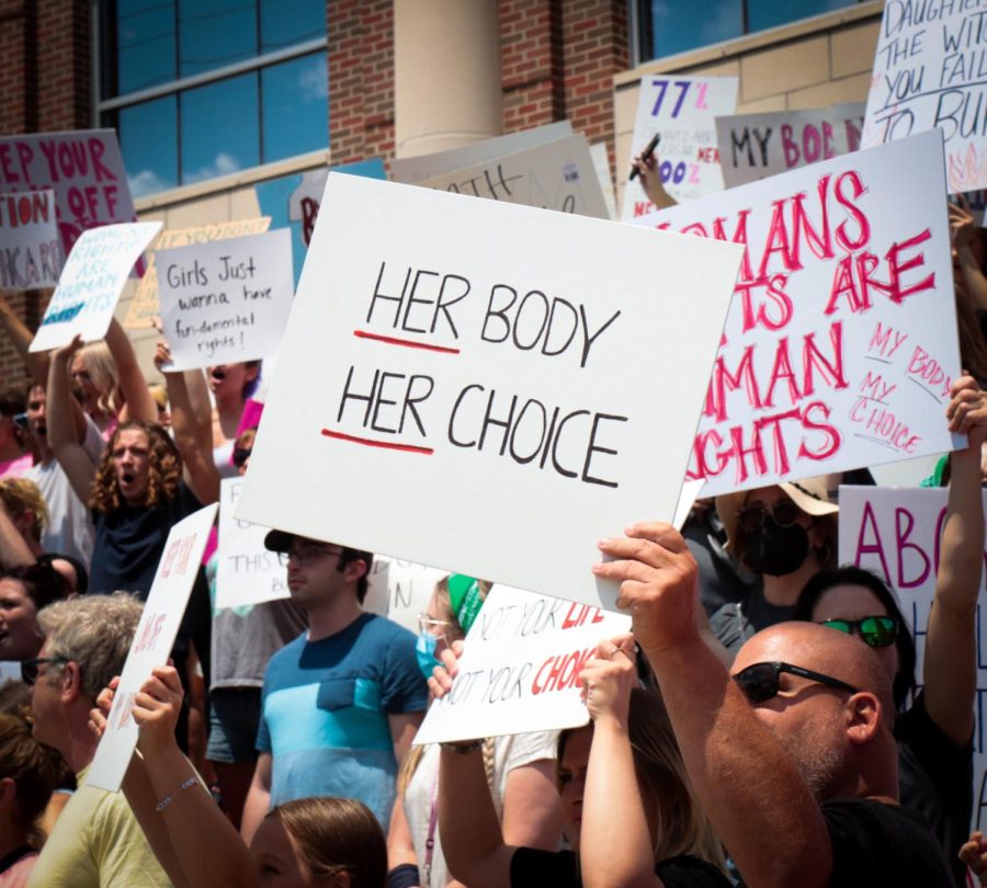 A protester holds a sign that reads Her body her choice in front of the Portage County Municipal Courthouse at the pro-abortion rights rally at Kent State on Wednesday, June 29.