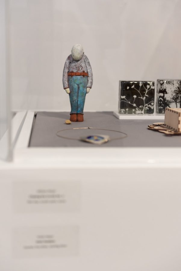 William Meyers artwork, Chasing the Crumb No. 2, is displayed in a glass case along with other Kent State artists work.