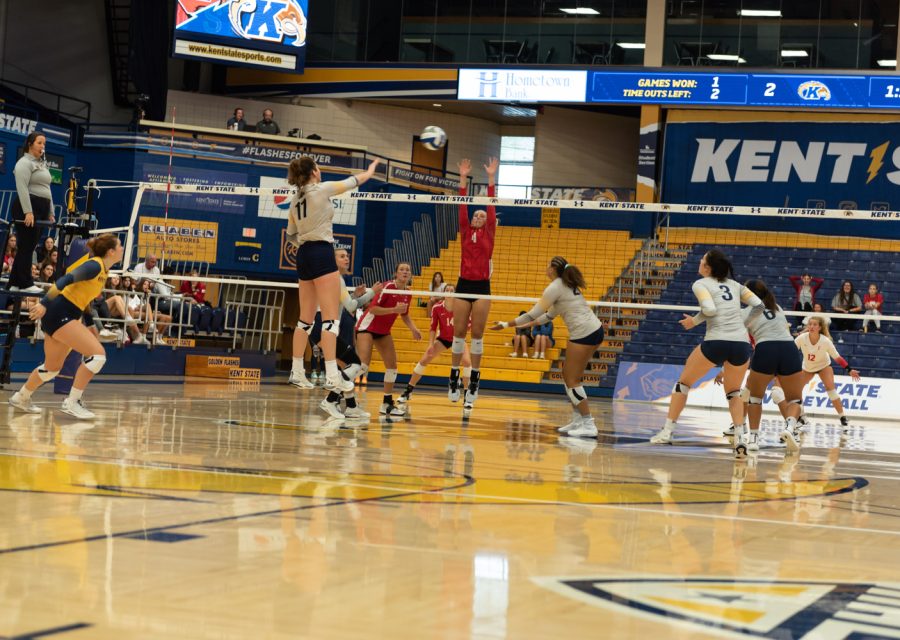 Outside hitter Mackenzie McGuire hits the ball over the net as a Corrnell University player attempts to block it. The crowd was cheering each team on during the Saturday morning game.