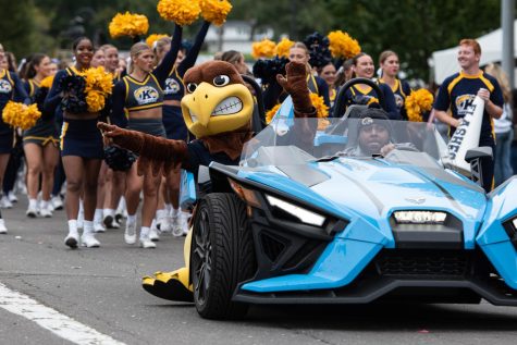 Flash the Golden Eagle rides ahead of Kent State athletes during the 2022 Homecoming Parade.
