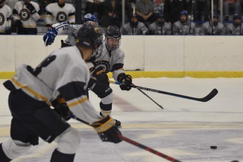 A duo of Kents hockey team members races the puck down the rink. 