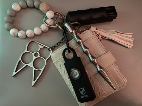 My keychain, featuring my wallet and a variety of self-defense tools: cat-shaped brass knuckles, a self-defense alarm, a blunt object and pepper spray.