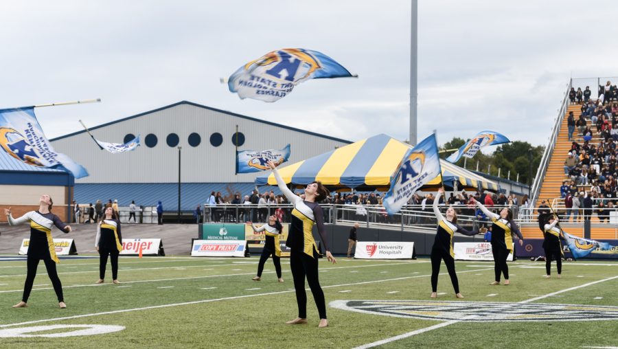 The Kent State Colorguard twirl their flags into the air. They performed with the band during halftime.