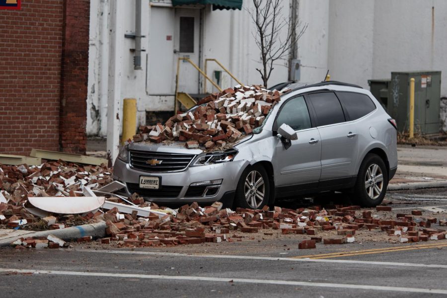 A car parked on the side of the street below the Star of the West Mills front entrance lies crushed by rubble blown from the building following an explosion caused by the fire.