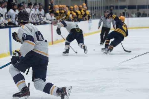 Kent State hockey team member Kyle Holmes slides to a halt after sending the puck down the ice to his teammate during the home game against West Virginia University on Jan. 28th, 2023.