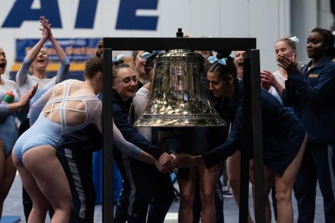 The Kent State gymnastics team rings the bell after pulling ahead of West Michigan University during the Beauty and the Beast meet on Jan. 29.