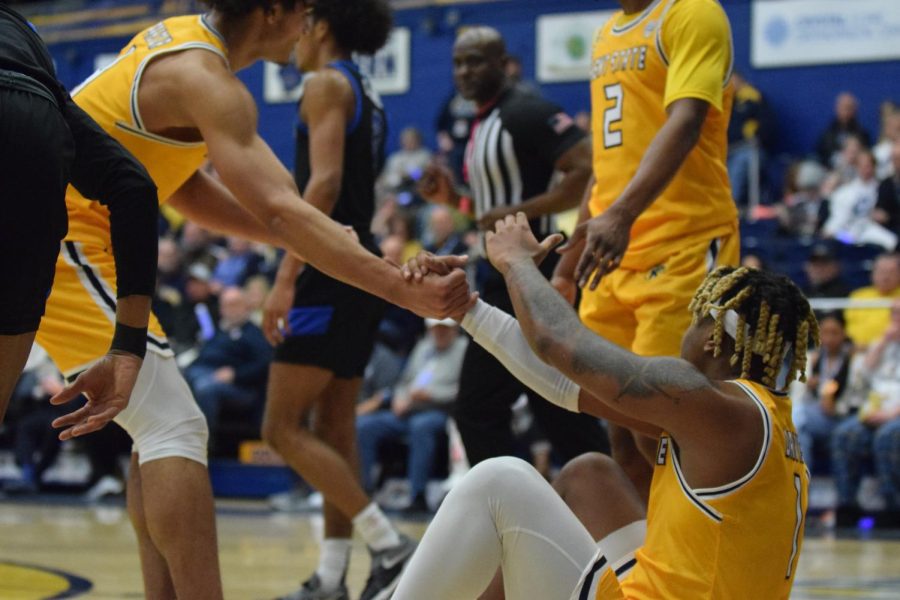 Seniors Chris Payton and Malique Jacobs help up Kent State teammate VonCameron Davis before preparing for his foul shots against the Buffalo Bulls.
