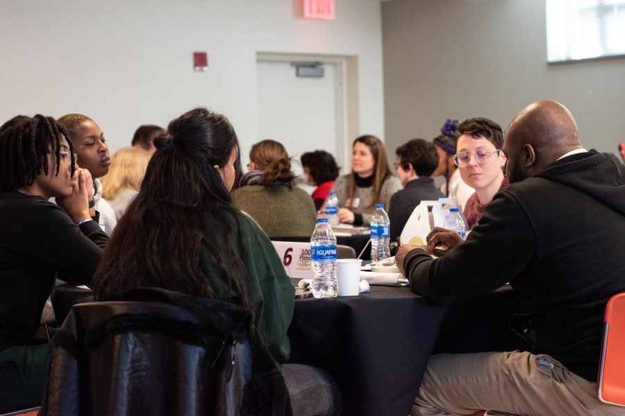 Attendees sit at tables spread across the room to discuss how to best help students in need following the initial presentation during the 100 plates community lunch on Feb. 1, 2023.