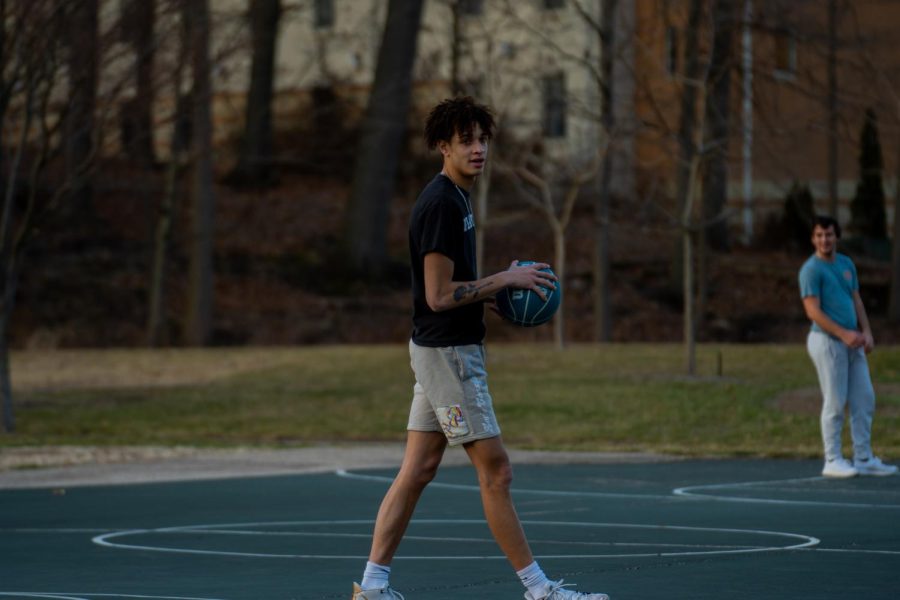 Freshman Elijah Barker practices basketball on the courts outside of Tri-Towers Feb. 23, 2023. 