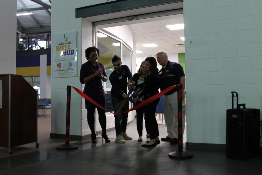Faculty and students cutting the ribbon to announce the opening of the Well Hub located in the Student Recreation and Wellness Center.