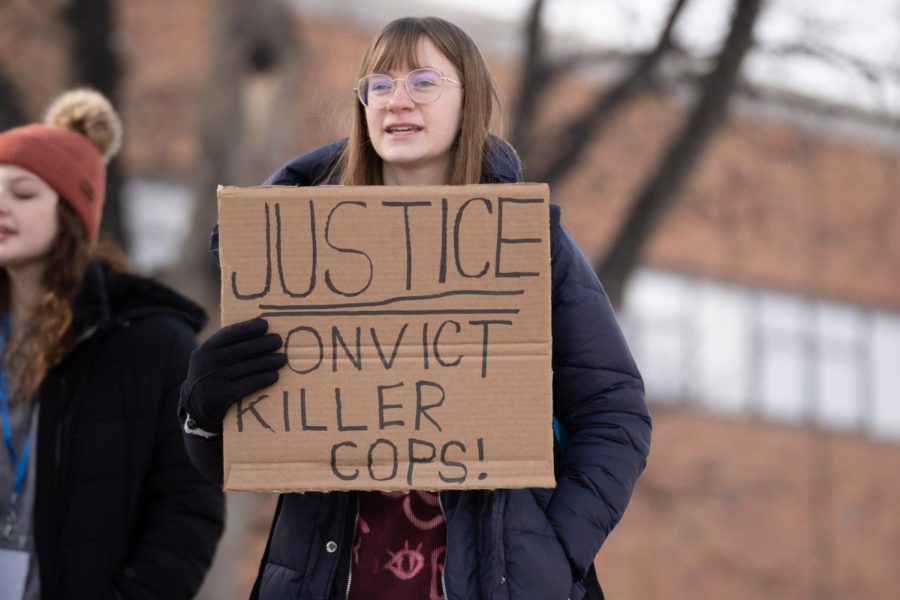 Maya Niesz Kutsch, cochair of SDS, holds a sign she made that says, JUSTICE CONVICT KILLER COPS! on Feb. 3, 2023.