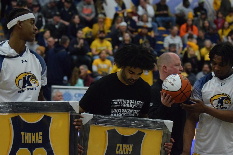 Kent Sate Seniors Miryne Thomas, Sincere Carry and Malique Jacobs observe the gifts they received at their senior night game on March 3, 2023. 