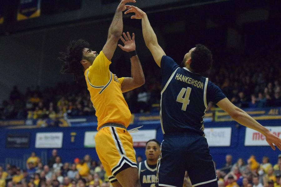 Redshirt senior guard Sincere Carry scores a point against the Akron Zips while Trendon Hankerson attempts to block him. 