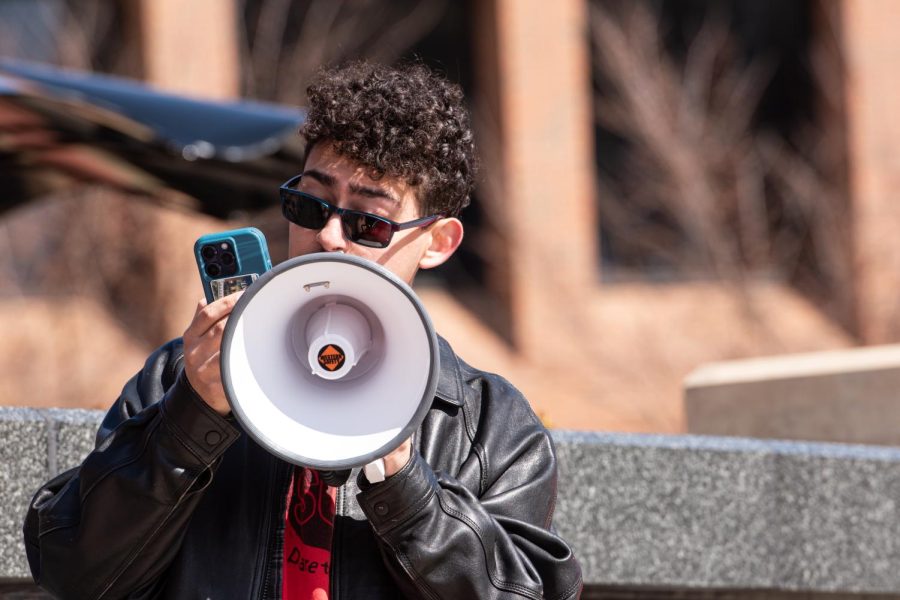 With a microphone in hand, Kent State junior Christian Heller speaks to a gathered audience about womens rights during the SDS speak-out March 8, 2023.