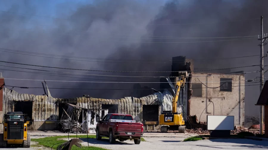 Workers knock down a section of site of an industrial fire the area as smoke billows from the site in Richmond, Indiana, on April 12.
Michael Conroy/AP
