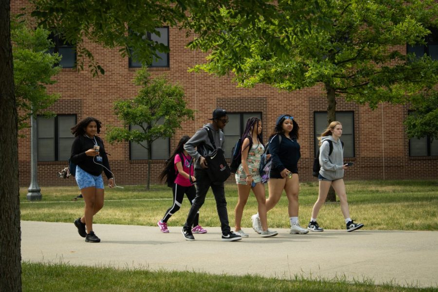 Students from the Upward Bound program chatting near Lake and Olson Hall. 