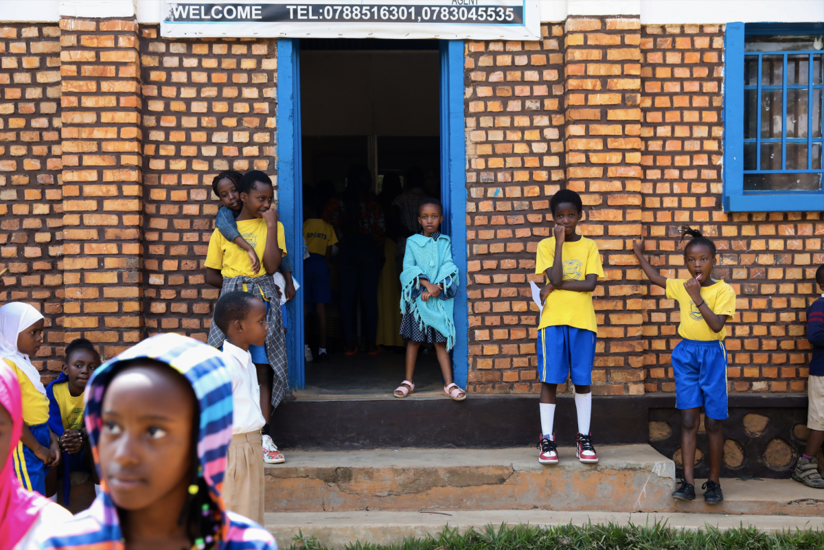 Primary school children stand outside the classrooms after school, waiting for their parents to pick them up.