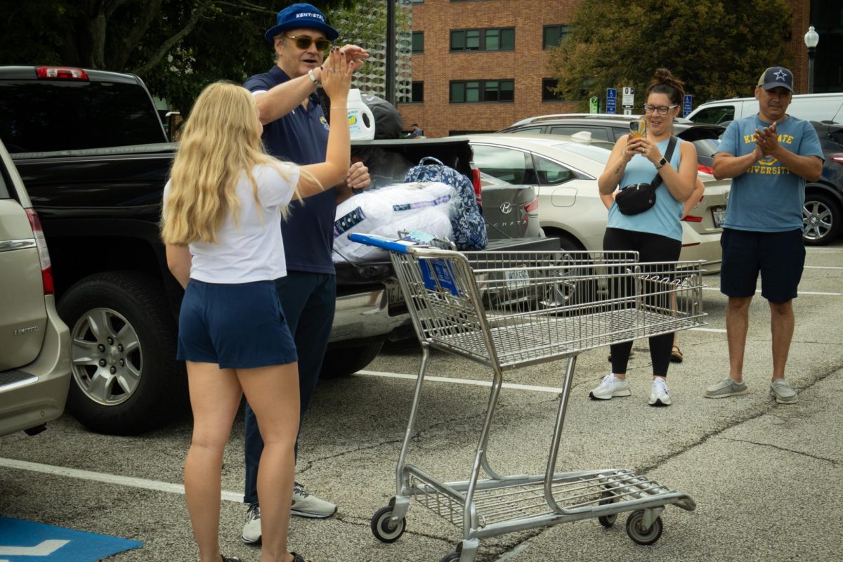 University president Todd Diacon high fives a student moving into their dorm outside of the Eastway Center on August 15th, 2023