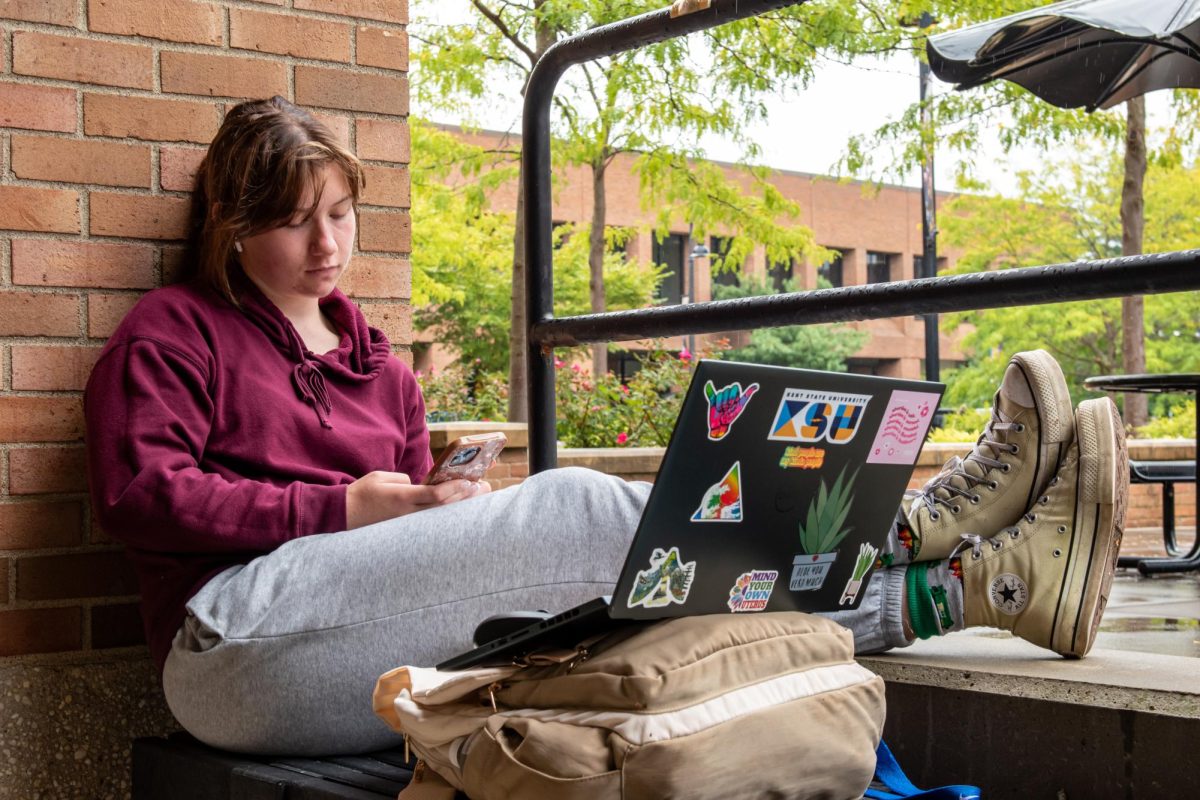 Junior digital media production major Isabelle Shreve takes a brief break from coursework as she studies below the eve of the Student Center and out of the rain on Sept. 14, 2023.