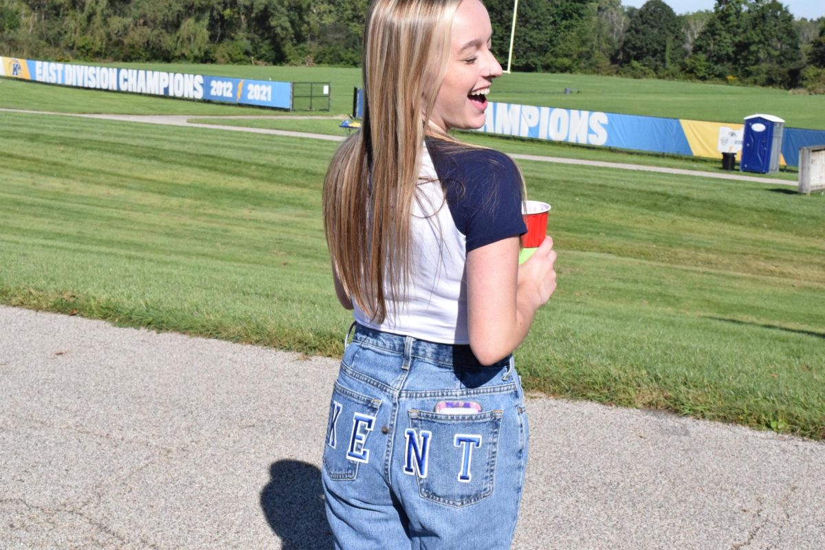 Kent State Student Addy Stormes shows off her homemade Kent jeans while she waits to get into Dix Stadium for the football game on Sept. 16, 2023.