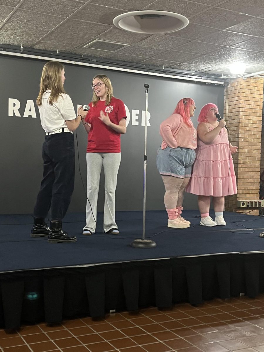 Attendees stand on stage singing their favorite tune during FABs karaoke event on Sept. 13, 2023.