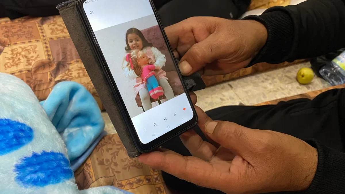 Ismail Abd Almagid looks at a picture of his daughter on his phone. Ivana Kottasova/CNN