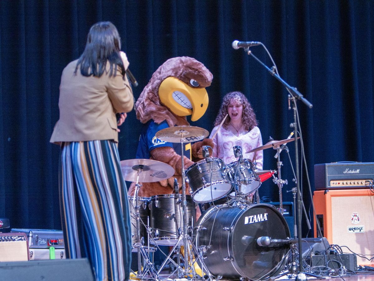 Flash, the beloved Kent State mascot, takes the drumsticks and shows off his rock skills before The Pit Crews set at Flash Activities Boards Battle of the Bands event on Nov. 4, 2023.