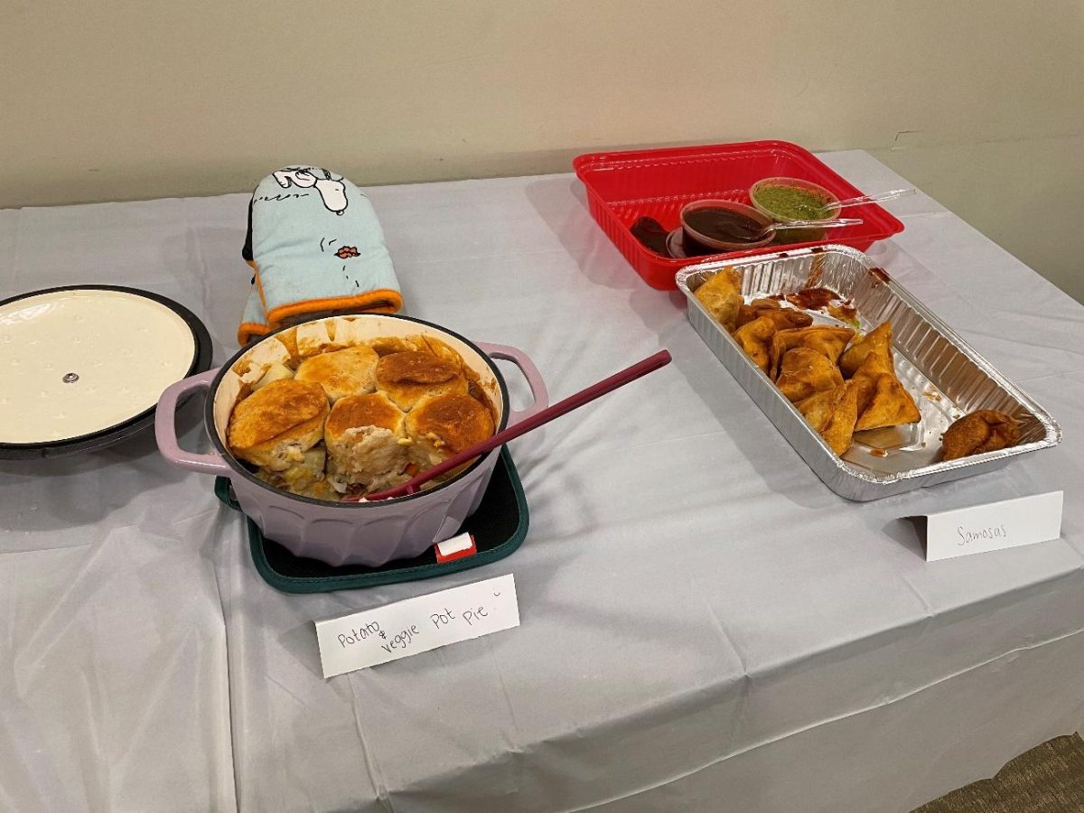 Samosas (right), an Indian traditional food and potato and vegetarian pot pie (left) sit on a table at the potluck.