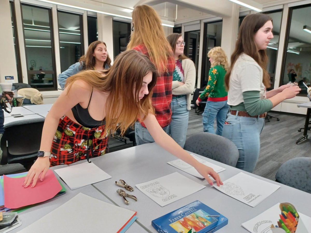 Students grabbing materials to create cards at AIGA design event Wrap Up The Semester on Dec. 6, 2023.