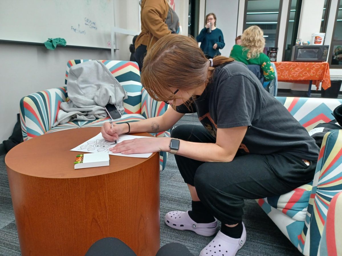 CCI student Alexandria Radde coloring cards during the AIGA Design event Wrap Up The Semester on Dec. 6, 2023.